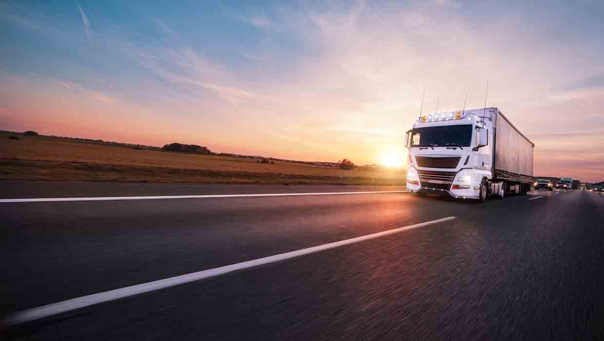 LKW auf einer Autobahn bei Sonnenauf- oder Untergang